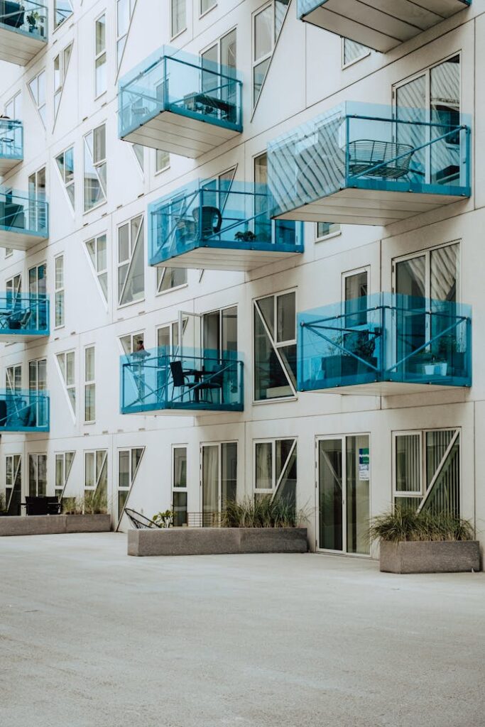 Stylish apartment exterior featuring blue glass balconies and contemporary design.