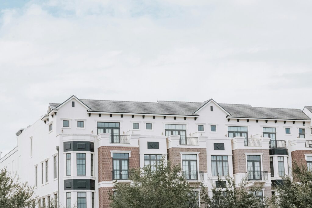 A stylish, multi-story luxury apartment building with a contemporary facade against a clear sky.